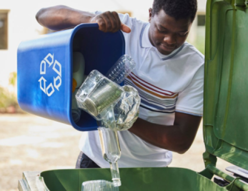Photograph of a person emptying plastics into a recycling bin