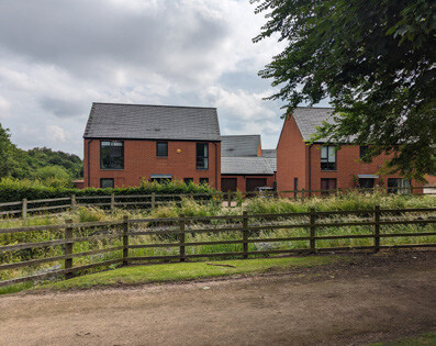 A photo showing detached homes overlooking a green edge