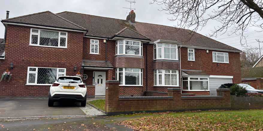 A photo showing semi-detached house with considerable extensions on each side